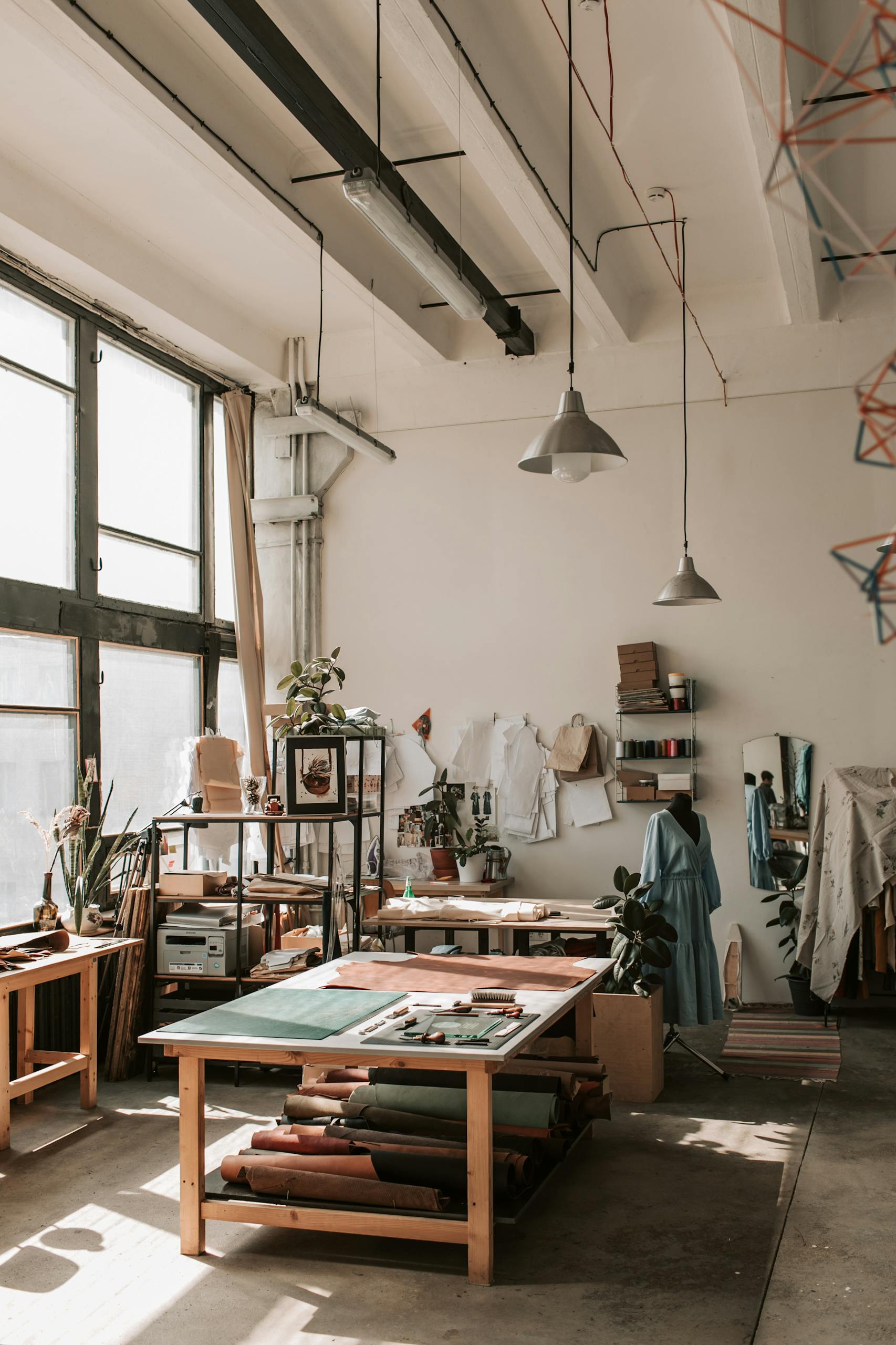 A spacious sunlit studio with crafting tables, tools, and supplies, perfect for artisans.