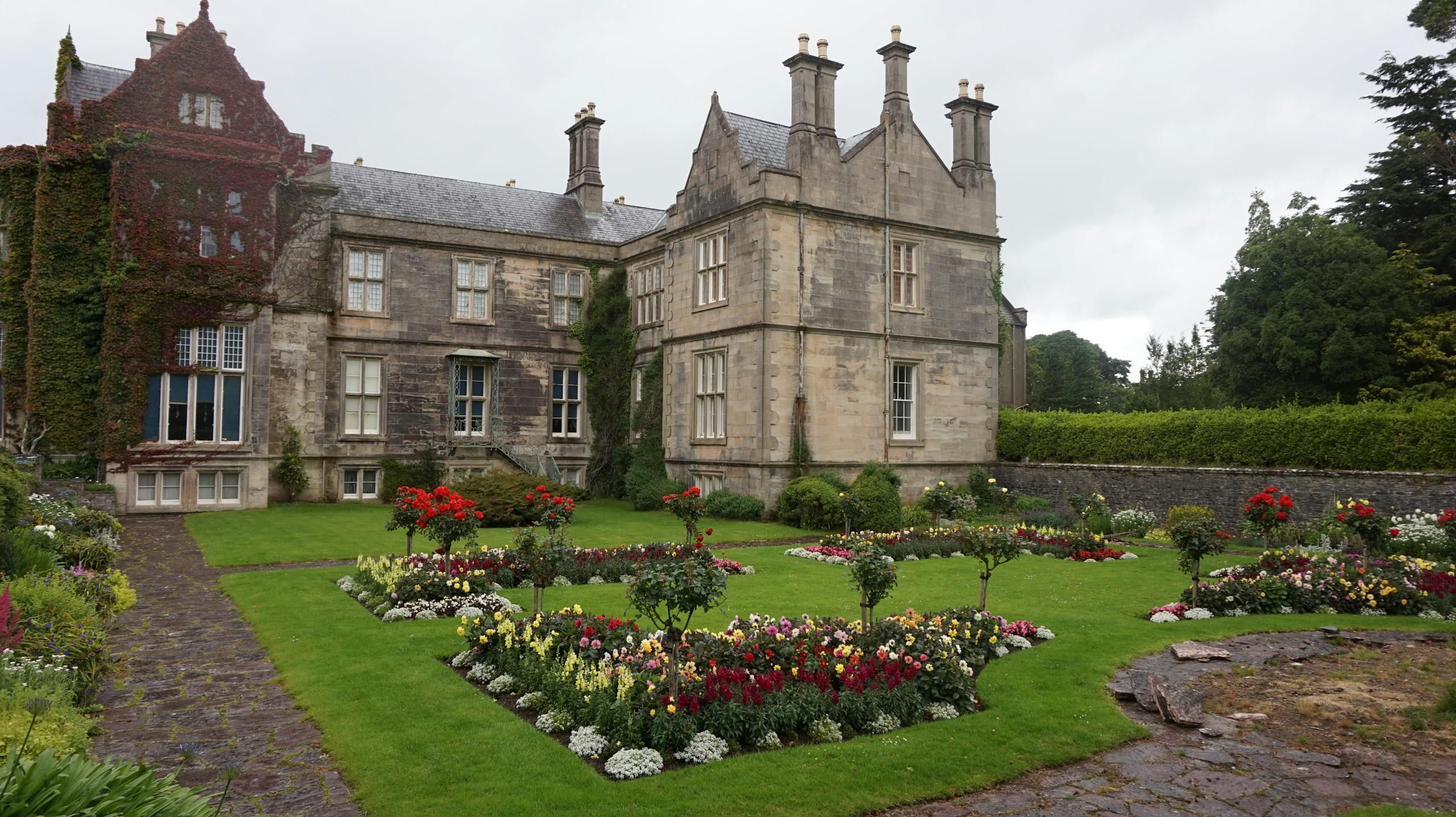 Beautiful view of the historic Muckross House surrounded by lush, manicured gardens.