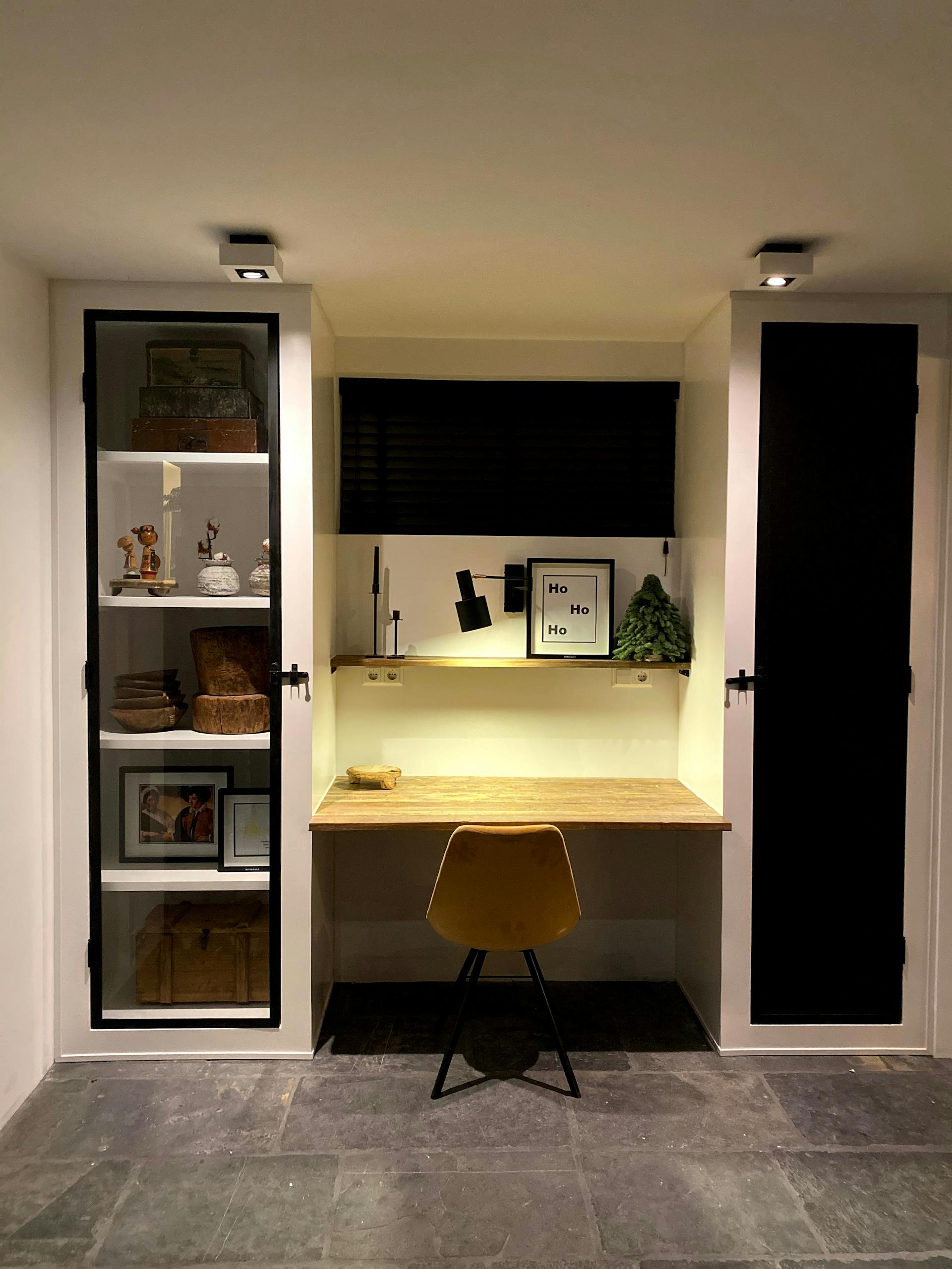 Modern home office with minimalist decor featuring a desk and shelving, perfect for focused work.